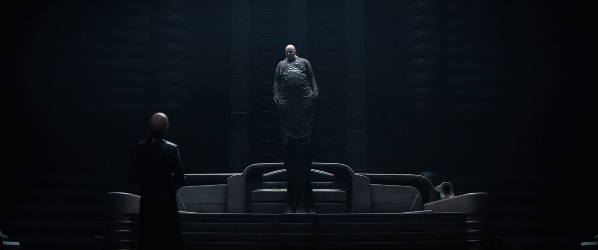Baron Harkonnen (Stellan Skarsgård) levitates above the ground as he speaks to his Mentat, Piter de Vries (David Dastmalchian), in the Dune (2021) movie. 