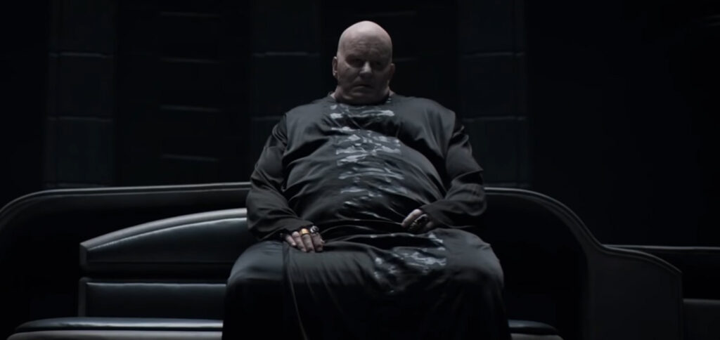 Baron Harkonnen (Stellan Skarsgård) seated in his throne room in the Dune movie (2021).