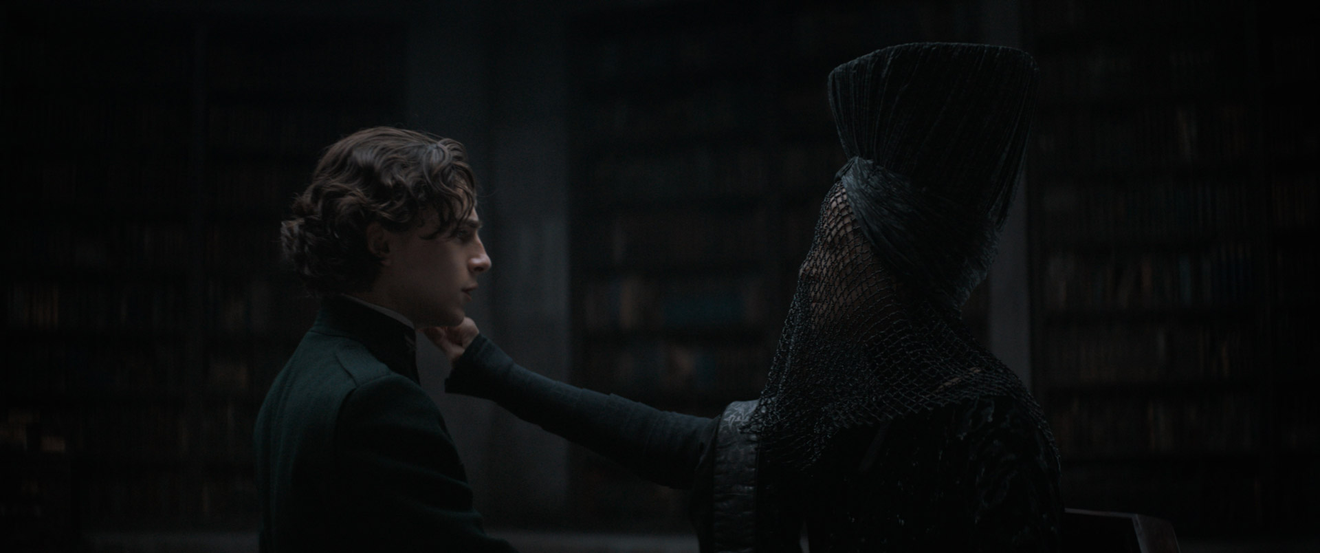 Reverend Mother Gaius Helen Mohiam (Charlotte Rampling) holds the Gom Jabbar to the neck of Paul Atriedes (Timothée Chalamet).