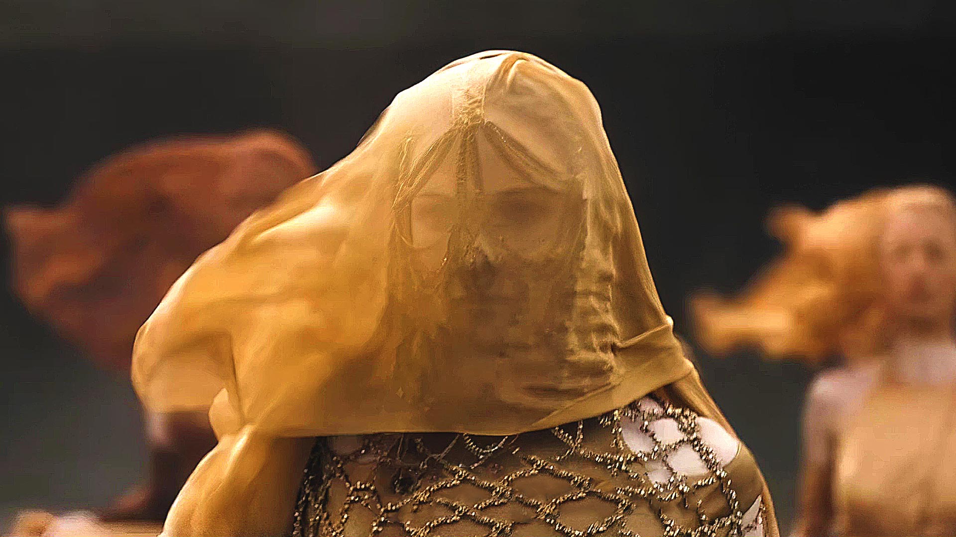 Lady Jessica, face covered by a veil, sets foot on Arrakis. The character is played by Rebecca Ferguson in Villeneuve's Dune movie.