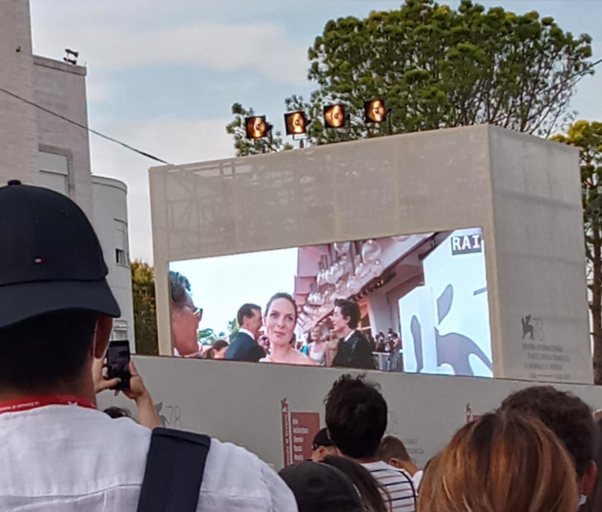 Crowds in Venice watching the Dune movie red carpet proceedings, on a big screen.
