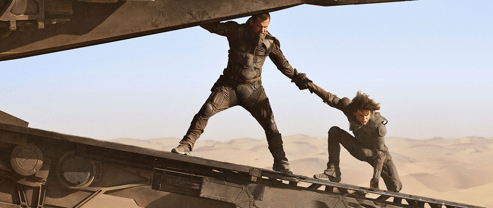 Gurney Halleck (Josh Brolin) and Paul Atreides (Timothée Chalamet) make a last-minute escape from a sandworm, in the spice harvester scene of the 'Dune: Part One' movie.