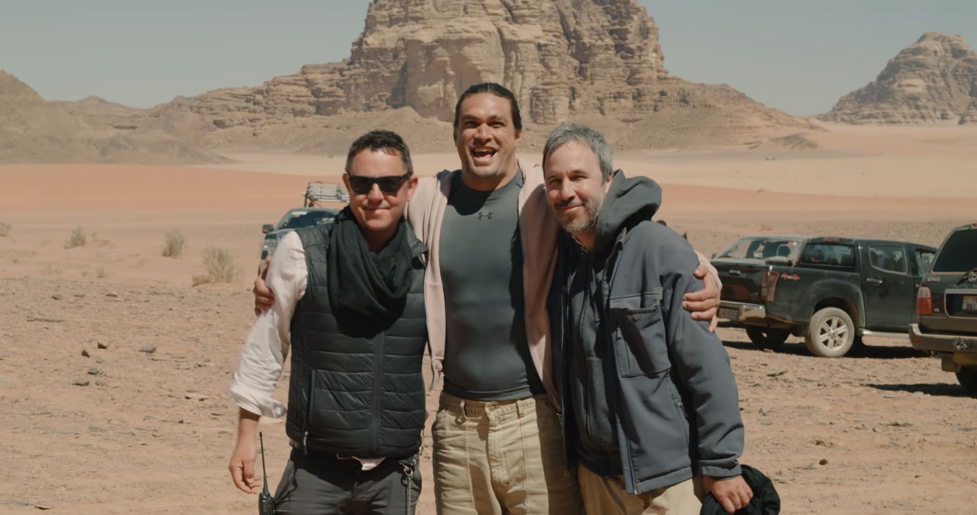 Dune movie behind-the-scenes photo. Denis Villeneuve, Greig Fraser, and Jason Momoa pose for a photo together in the Wadi Rum desert of Jordan.