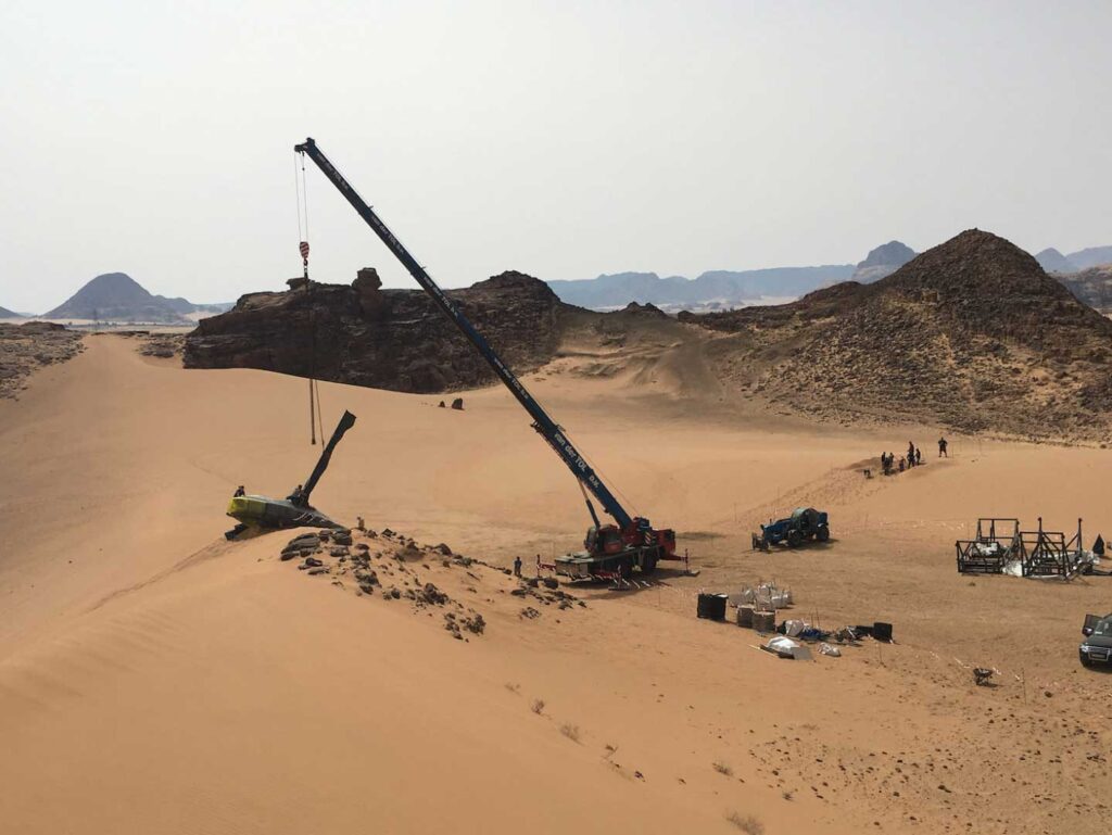Set of the 'Dune' movie in the desert of Jordan, featuring crane and downed ornithopter.