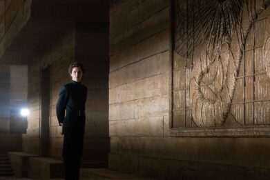Timothée Chalamet, playing Paul Atreides, stands in front of the sandworm mural, during production of the 'Dune' movie.