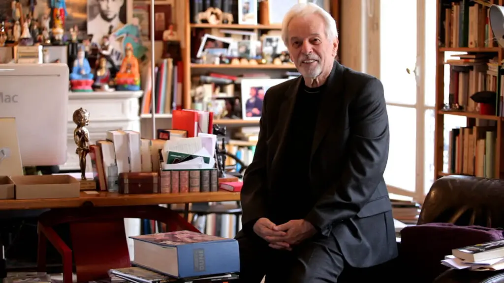Photo of Alejandro Jodorowsky with a copy of the "Dune bible", a large blue book containing the completed storyboards.