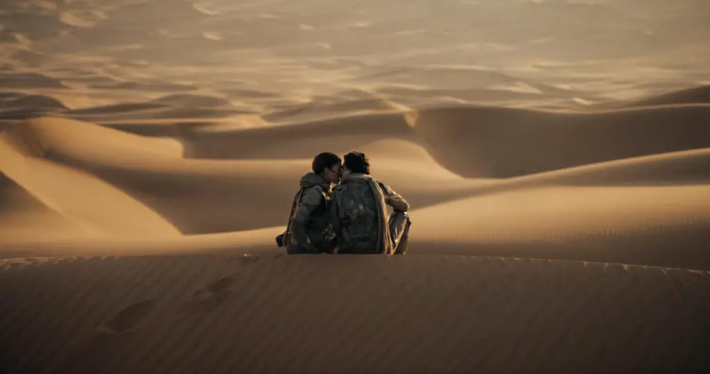 Chani and Paul kiss among the sand dunes in Denis Villeneuve's 'Dune: Part Two' movie.