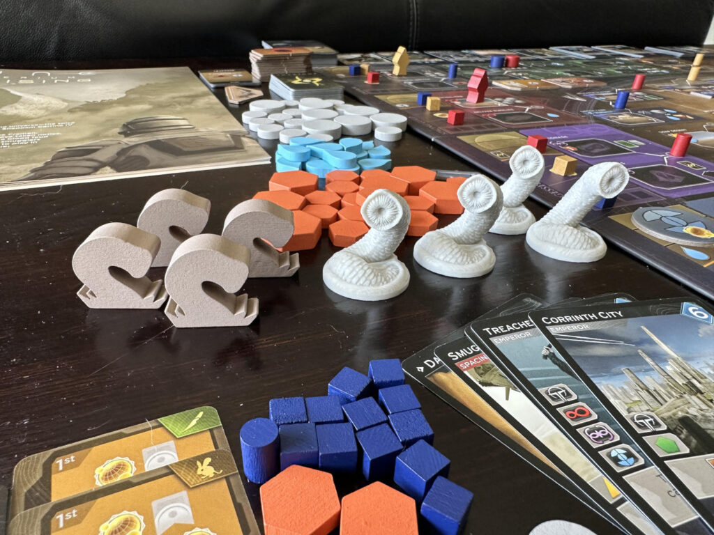 Wooden and plastic sandworm figures in 'Dune: Imperium - Uprising', a board and card game design by Dire Wolf.