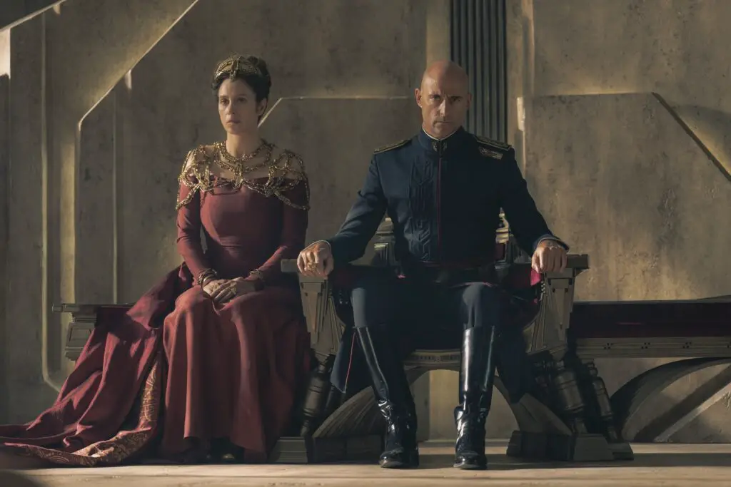 Shot of Emperor Javicco Corrino (Mark Strong) seated with Empress Natalya (Jodhi May) in 'Dune: Prophecy'.